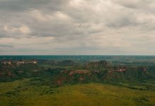 Vista aérea de paisagem verde do Cerrado, com campos extensos e formações rochosas no Tocantins.