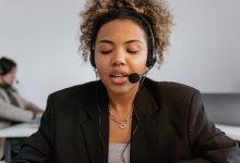 Atendente de serviço ao consumidor usa fones de ouvido em um ambiente profissional de atendimento.
